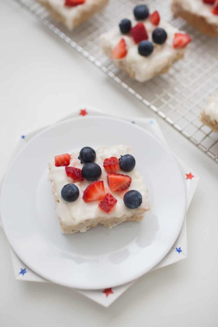 All-American Sugar Cookie Bars, the perfect patriotic dessert! Light cookie bars topped with homemade icing and fresh strawberries and blueberries. Celebrate American with this festive dessert! sugar cookie | cookie recipe | sugar cookie bar | cookie bars | july 4th dessert | july 4th recipe | independence day dessert | red white blue dessert | patriotic dessert | fruit dessert | strawberry dessert | blueberry dessert
