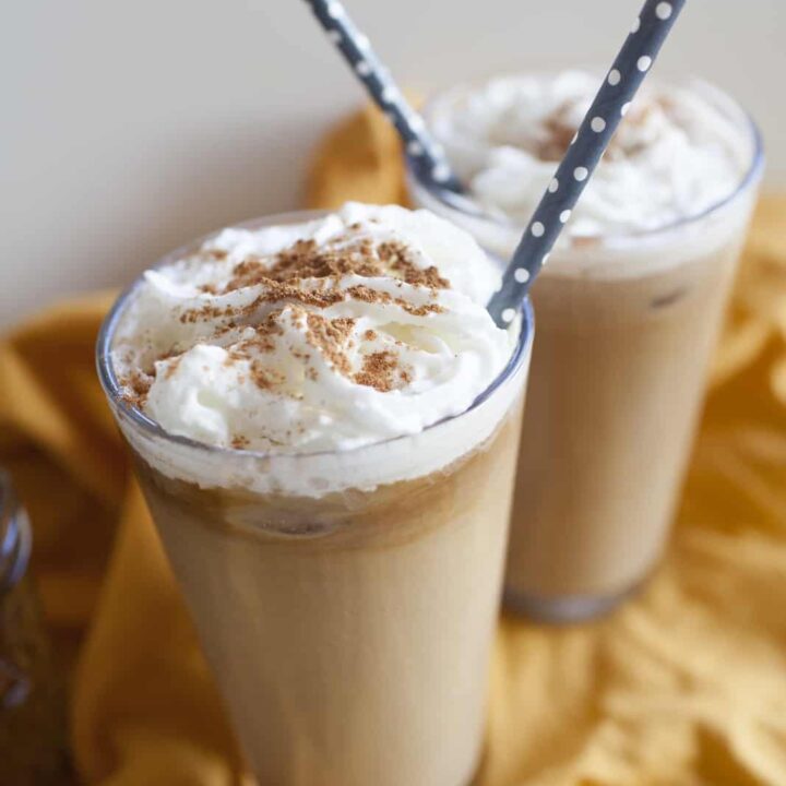 Two cups of coffee with homemade whipped cream and a sprinkle of cinnamon.