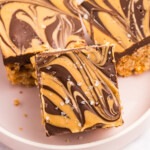 An exclusive plate of Chocolate Peanut Butter swirl bars, topped with flaky sea salt, offers a delicious twist on classic Rice Krispie Treats.