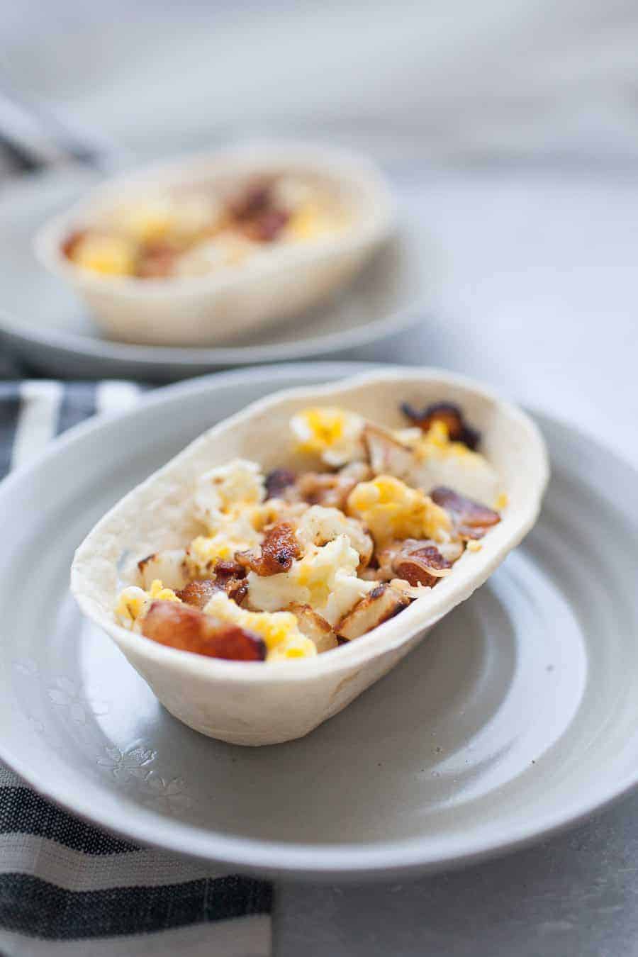 These bacon breakfast scramble bowls are the perfect way to start the weekend! Customize these bowls with your favorite breakfast protein, veggies, and toppings like cheese, green chile or salsa. Or keep them simple with potatoes, eggs and bacon! Either way, these breakfast bowls are sure to be a hit with your family. 