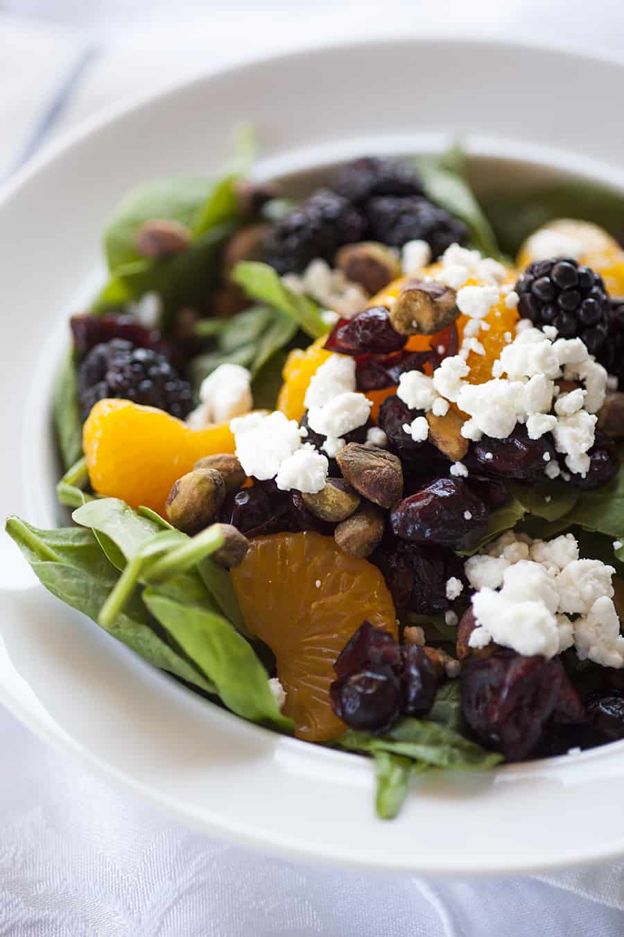 This citrus berry spinach salad is loaded with ingredients like pistachios, cranberries, goat cheese, oranges and blackberries and it's perfect for a summer salad!