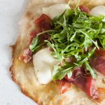 Overhead photo of pizza topped with arugula.