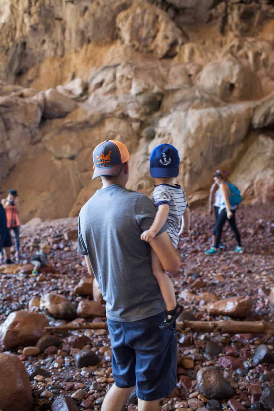 A group of people making memories with a toddler in a rocky area.