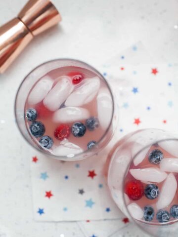 Celebrate summer and July 4th with this beautiful patriotic triple berry spritzer. Made with a triple berry simple syrup, tequila and lemon lime soda it's the perfect way to enjoy the summertime! 4th of july cocktail | patriotic cocktail | berry cocktail | triple berry spritzer | patriotic drink | berry drink | summer cocktail | tequila cocktail
