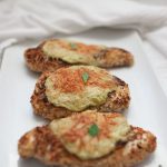 Cheesy Parmesan Chicken topped with herbs.