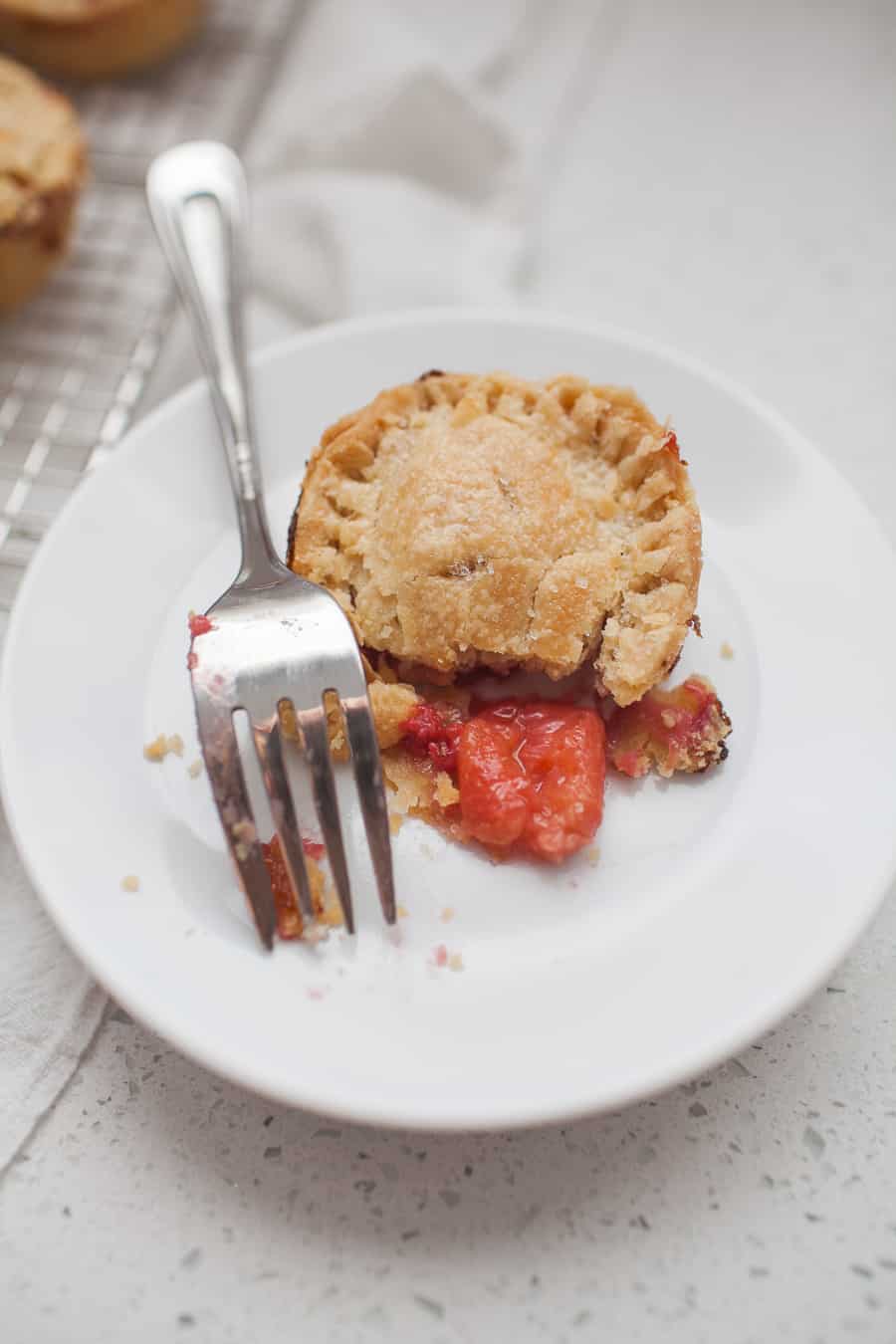 Mini strawberry pies on a plate with a fork.