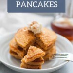 A stack of sweet potato pancakes topped with butter on a white plate, with a fork holding a bite-sized piece in the foreground and a jar of syrup in the background. Text reads "sweet potato PANCAKES." Enjoy your breakfast before cooling off with lemonade popsicles!