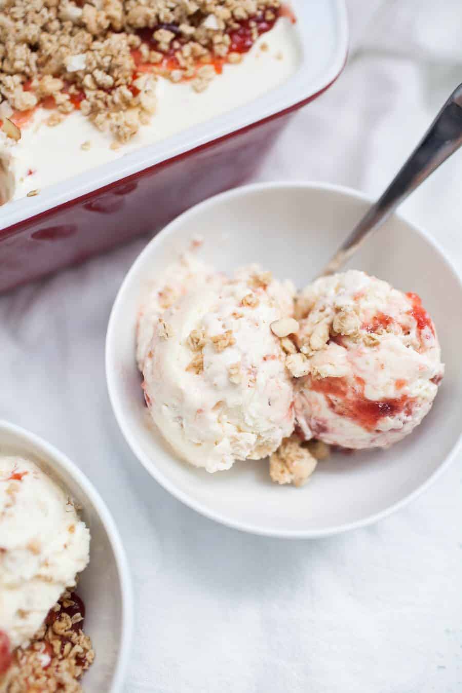 Two bowls of strawberry ice cream with granola and spinach.