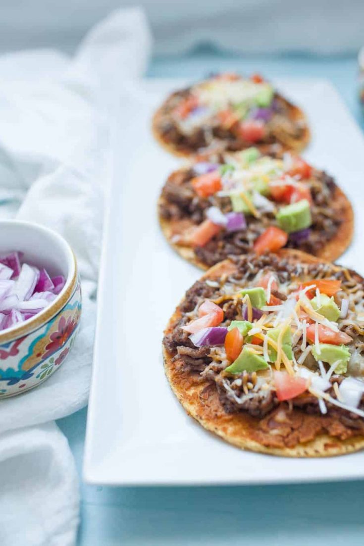 Easy ground beef tostadas are the perfect dinner for busy weeknights! They're quick to make and can be customized a ton of ways to be your perfect flavor combination! Start with a flat, crunchy corn tortilla and add your toppings like beans, ground beef, tomatoes, avocado and cheese for a flavorful, quick dinner.?