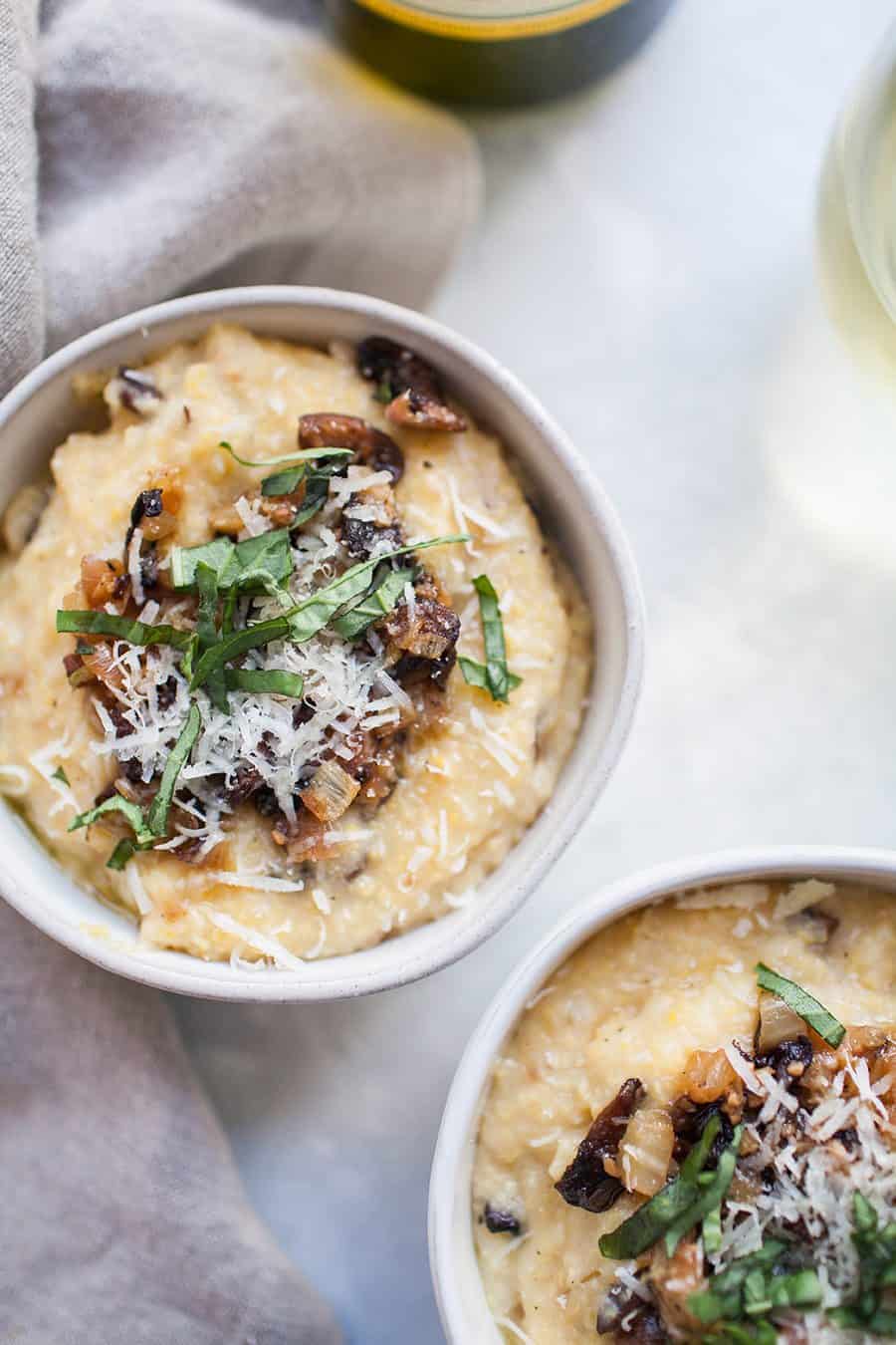 Two bowls of creamy risotto with mushrooms and parmesan cheese.