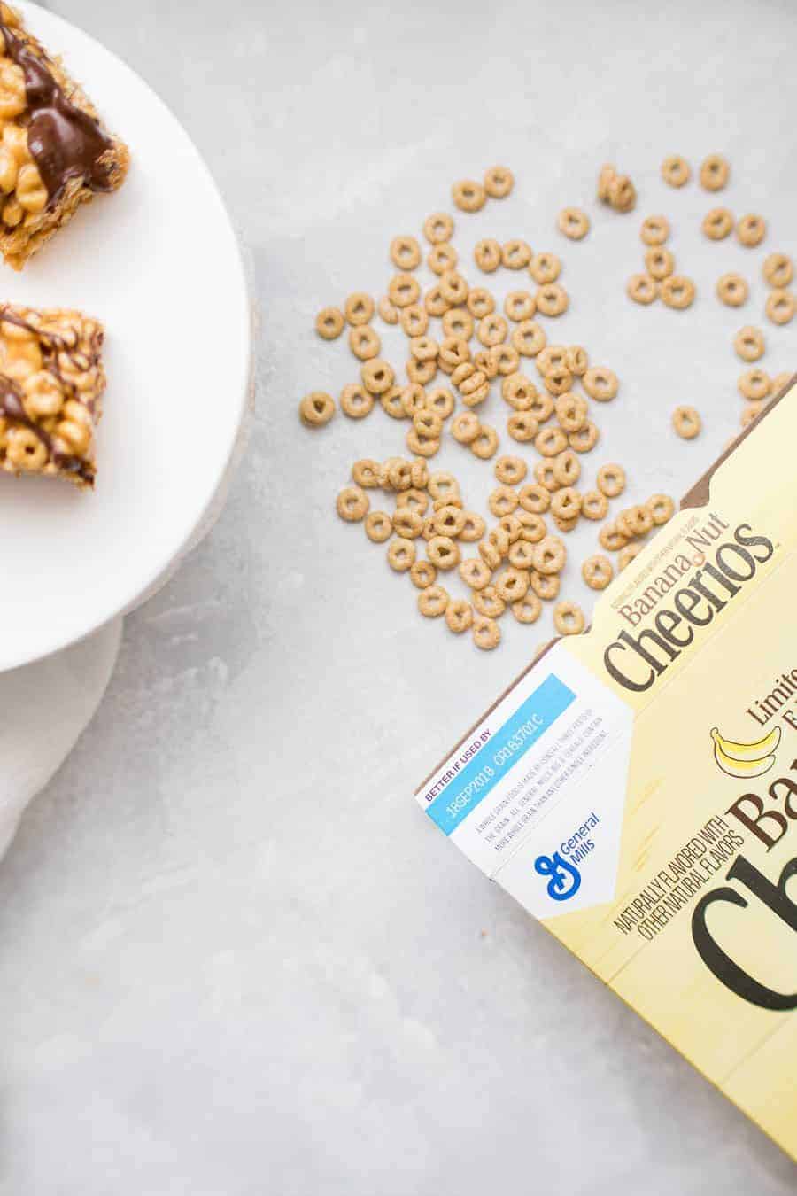 Simplify your breakfast routine with these dangerously yummy No Bake Banana Peanut Butter Cereal Bars. Made with new Banana Nut Cheerios, peanut butter, honey and chocolate drizzle, these no bake cereal bars are super easy to make at the beginning of the week and enjoy on the go! If you're looking for a way to make your mornings simpler, these breakfast bars are the solution!