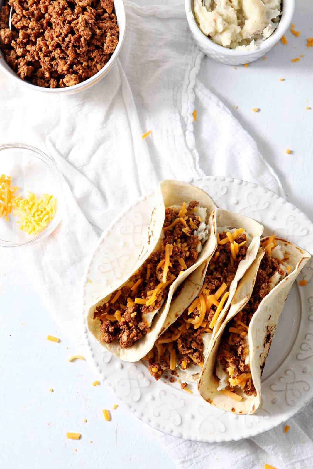 In search of the ultimate comforting breakfast? Look no farther than Mashed Potato Chorizo Breakfast Tacos! These tacos, made with store-bought chorizo and homemade mashed potatoes, are the stuff dreams are made of. They cook up quickly to create a flavorful meal! Easy to make ahead of time and freeze, these breakfast tacos are an ideal dish to bring a new mama, friends who moved, etc. Mashed Potato Chorizo Breakfast Tacos are an amazing meal!