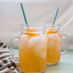 Two mason jars filled with homemade honey orange lemonade and ice.