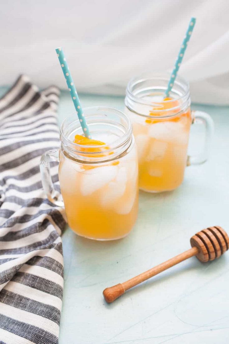 Two mason jars filled with honey orangeade.