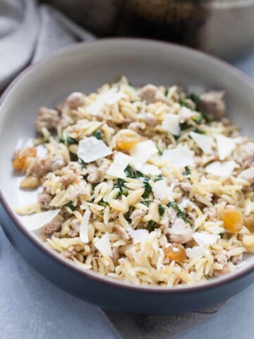 Spinach Turkey Orzo is a super easy meal that is packed with flavor for a perfect quick dinner option! This orzo dish has ground turkey, spinach, pine nuts, golden raisins and is topped with olive oil and shaved parmesan. The complexity of flavors in this dish is amazing, but you don't have to spend a long time getting this dinner together!