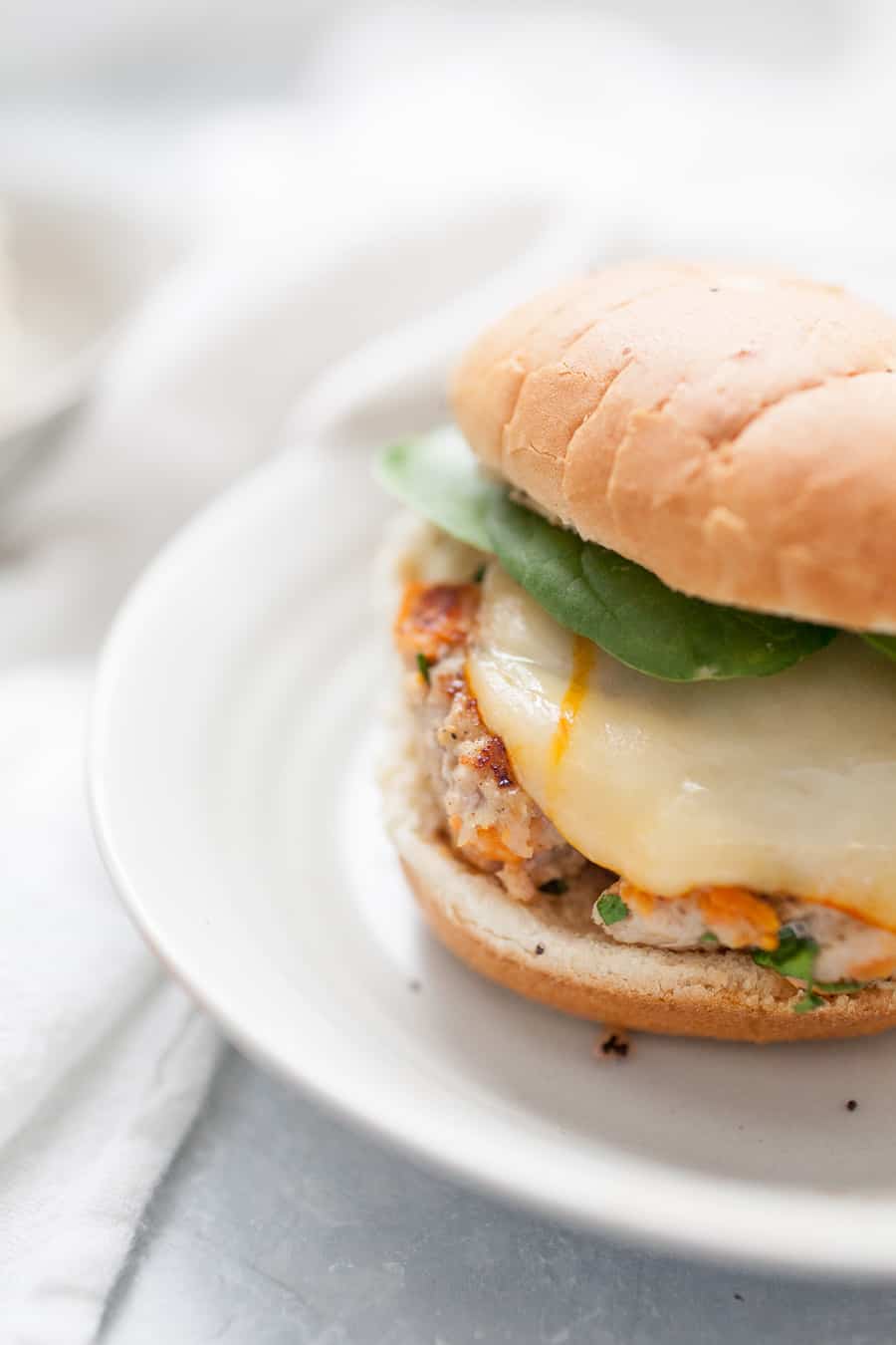 Homemade burgers are so easy to make and the taste can't be beat! This quick recipe is perfect for dinner on the table in under 30 minutes. These homemade sweet potato turkey burgers are made with spinach, sweet potatoes, ground turkey, and spices and topped with cheese on an onion bun. It's such a simple burger but packed full of flavor!