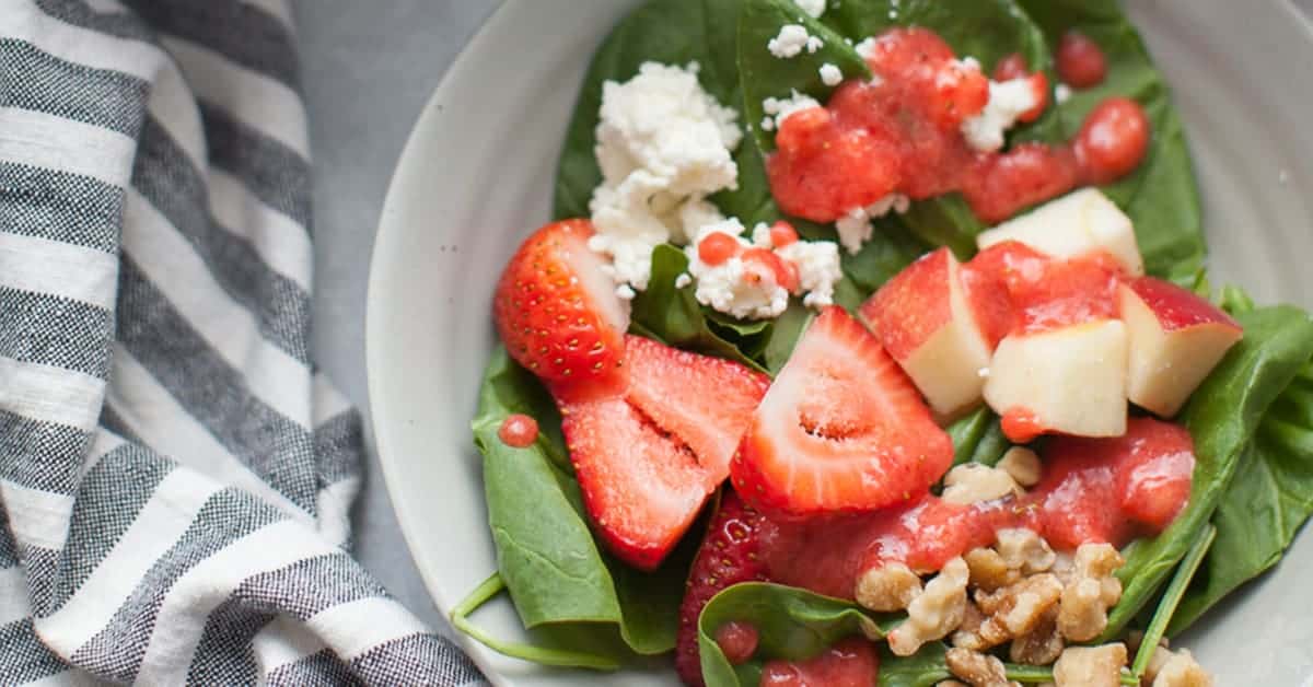 strawberries and pink dressing on a green salad.