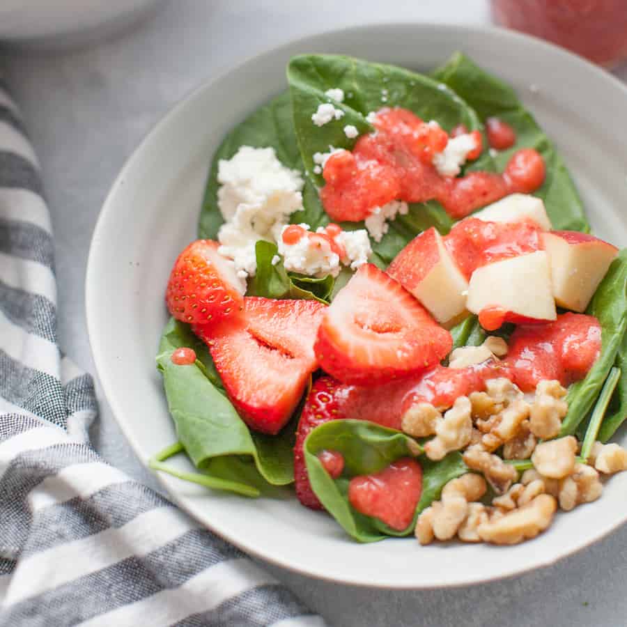 An overhead shot of a bowl of strawberry spinach salad.