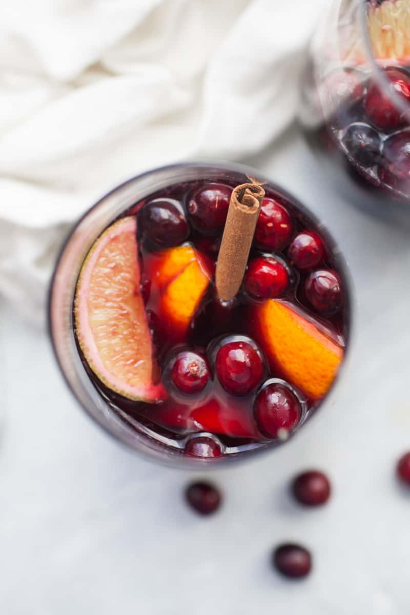 Glass of sangria made with lime, orange and cranberry.