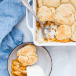 Square baking dish with peach cobbler.