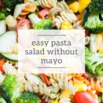 Close-up of a colorful pasta salad with rotini, broccoli, tomatoes, bell peppers, and cucumbers—perfect alongside a Fresh Fruit Salad—with a text overlay reading "easy pasta salad without mayo.