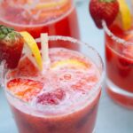 a closeup photo of the strawberry lemonade mocktail with slices of lemon and strawberries for garnish