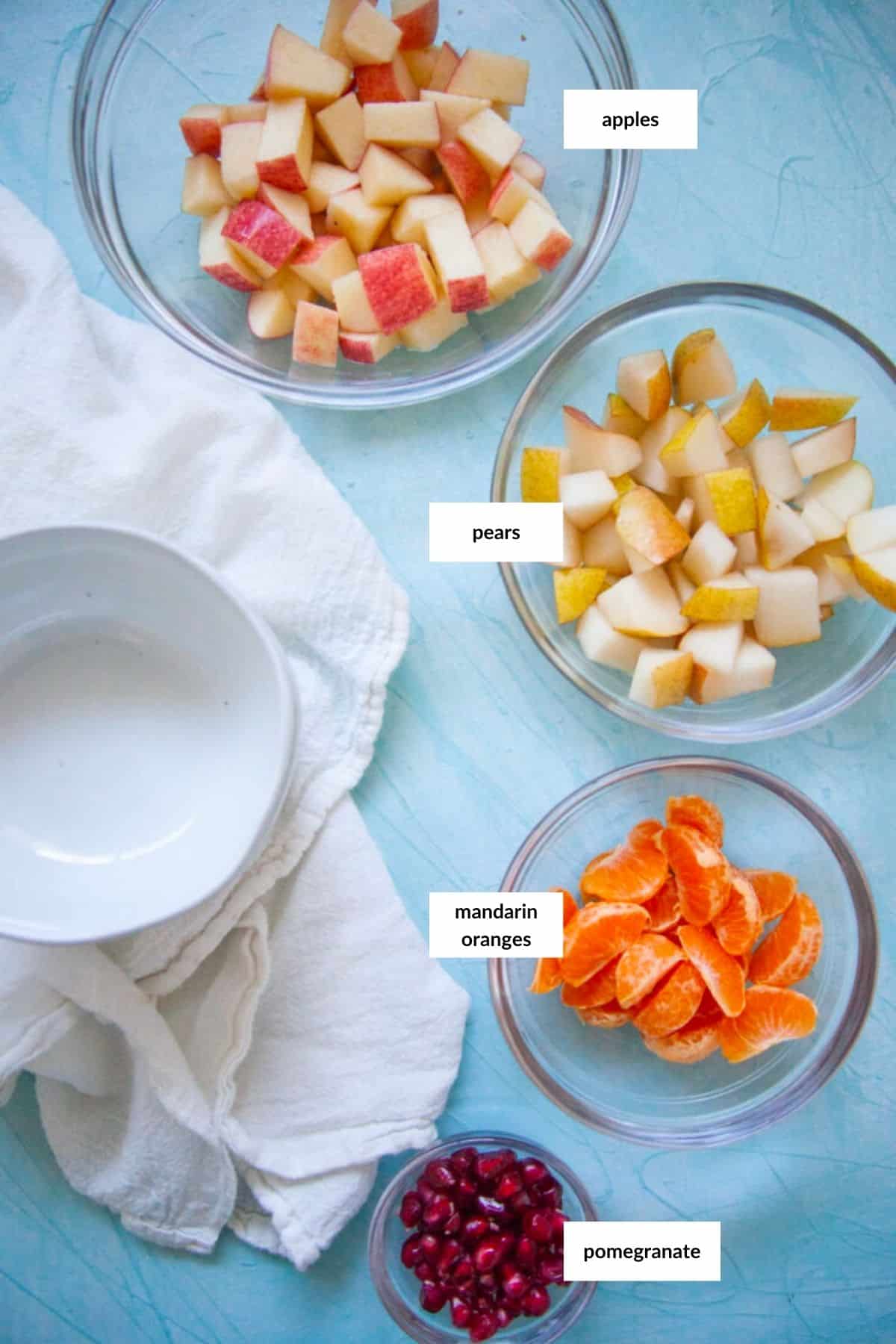 A Thanksgiving fruit salad consisting of a variety of apples, oranges, pears, and cranberries in a bowl.