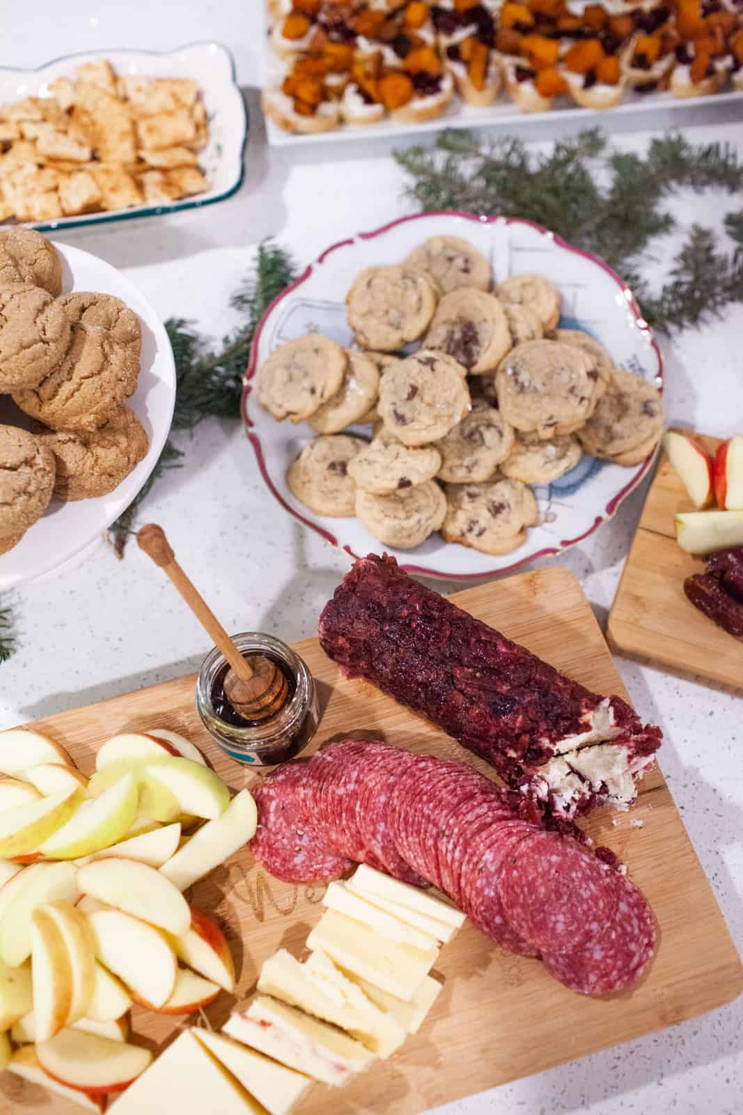 Platters filled with cookies and cheeses at a holiday wine party