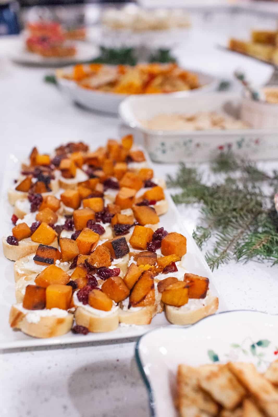 Crostini appetizers on a platter at a Christmas wine party.
