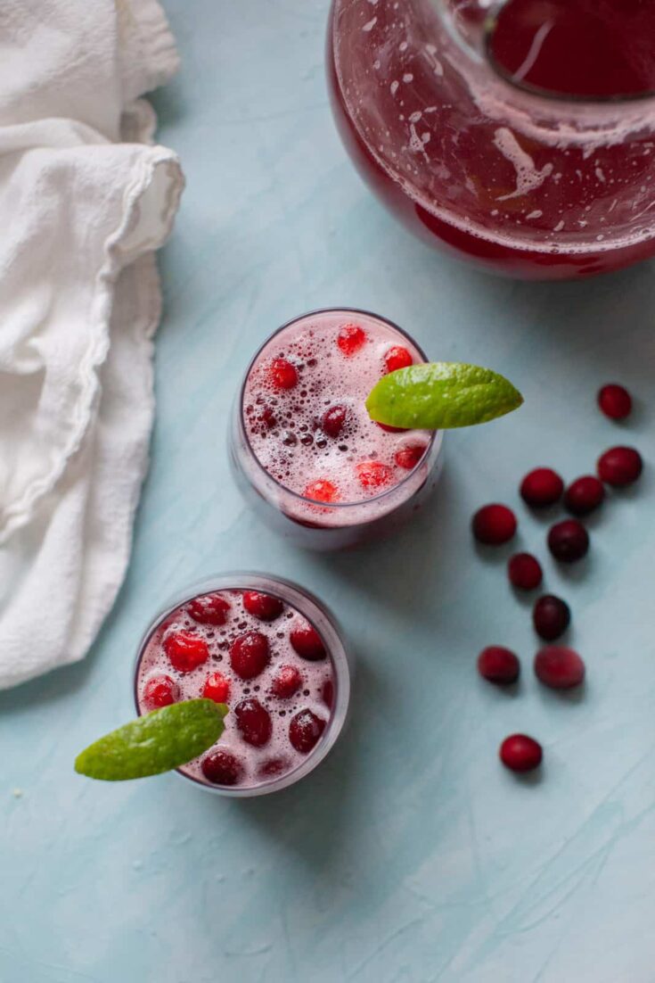 two cranberry ginger ale mocktails on a blue background