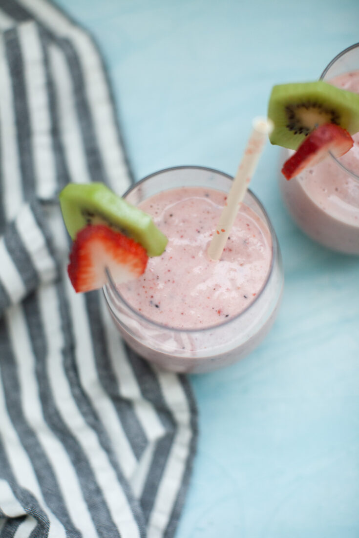 top view of a strawberry kiwi smoothie on a blue background 