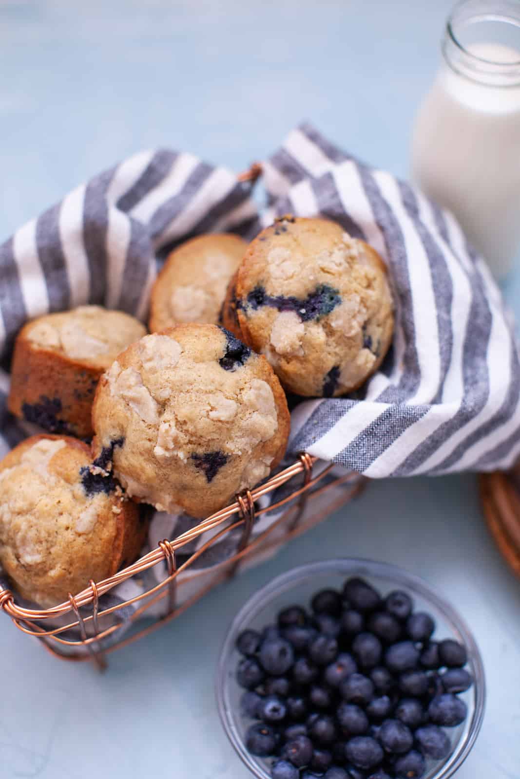 a basket of blueberry muffins on a striped kitchen towel