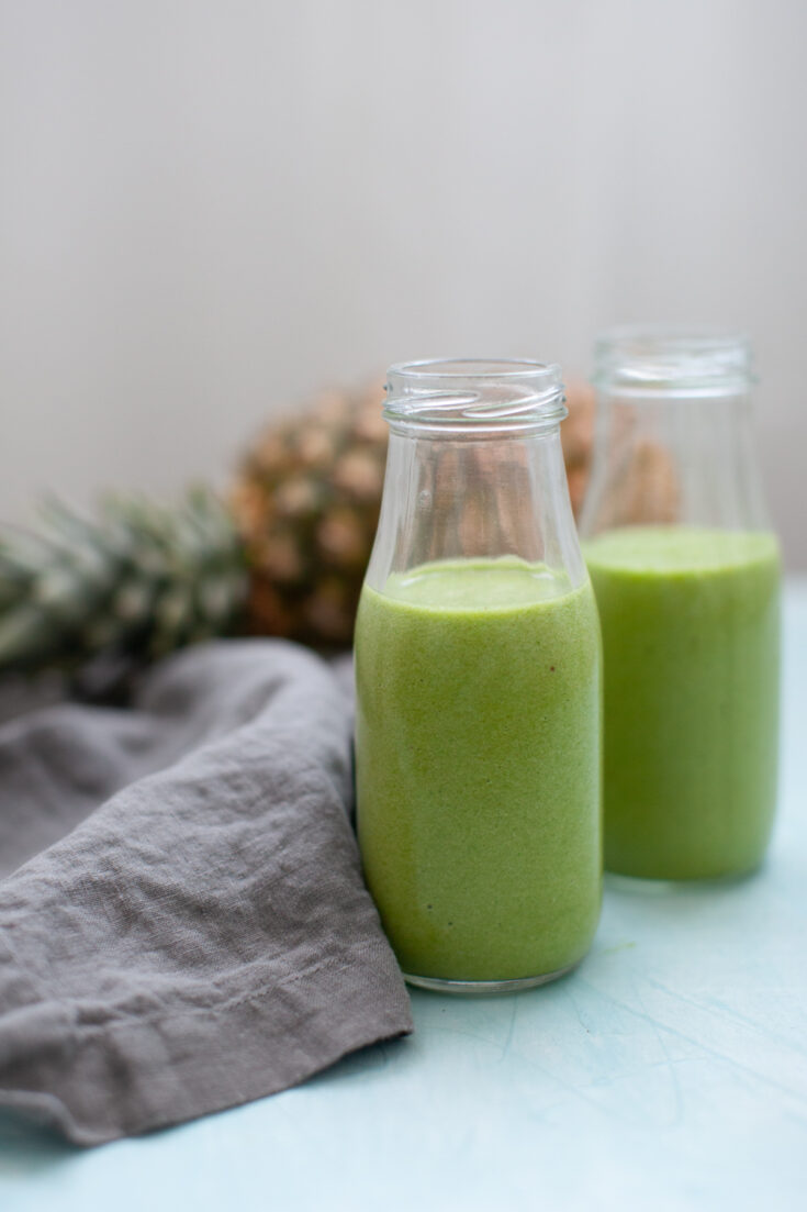 two Tropical Island Green Smoothies with a pineapple