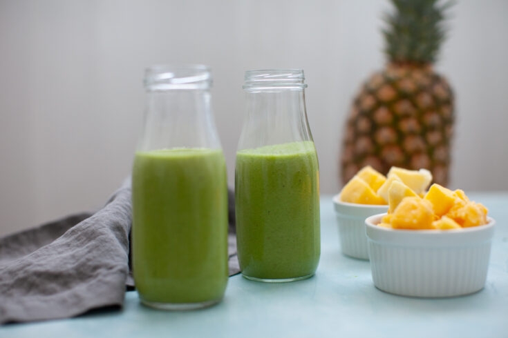 bowls of pineapple and mango with two Tropical Island Green Smoothie