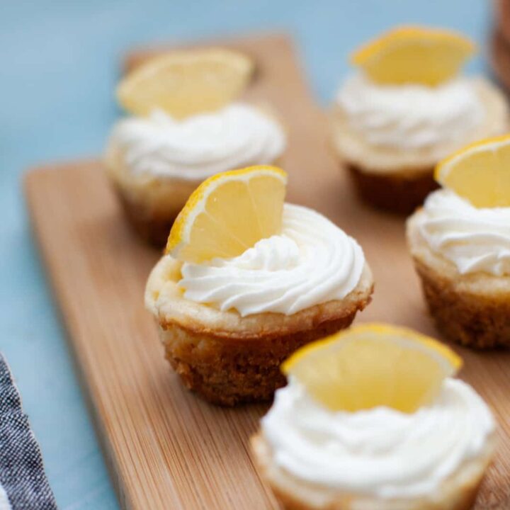 mini lemon cheesecakes on a wood board