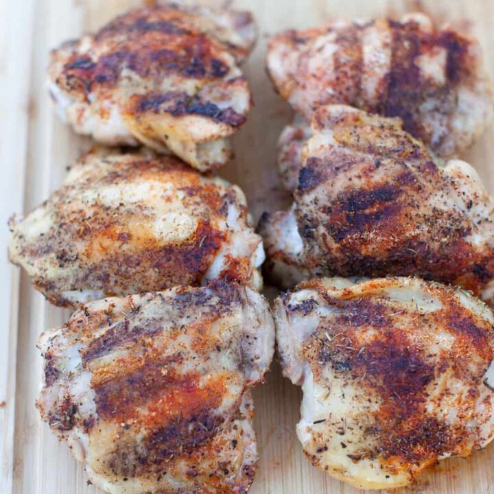 grilled chicken thighs on a wooden board