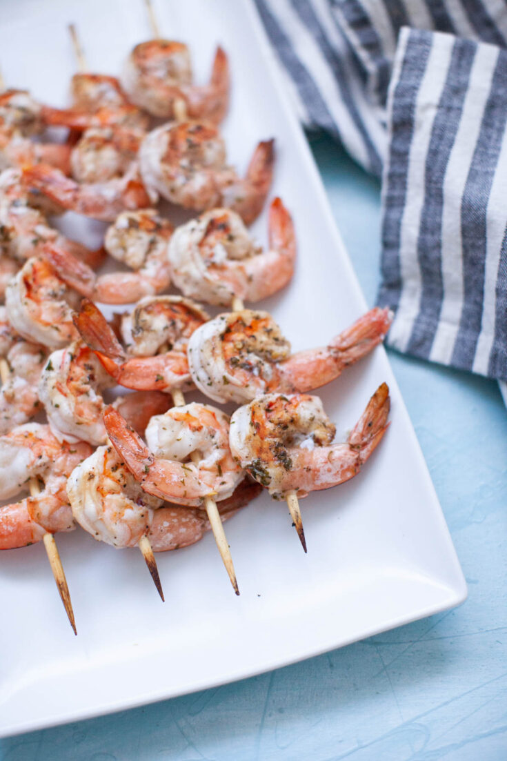 cooked shrimp skewers on a white plate