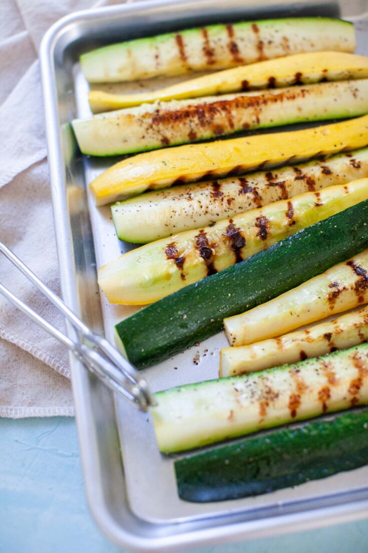 tongs picking up squash and zucchini