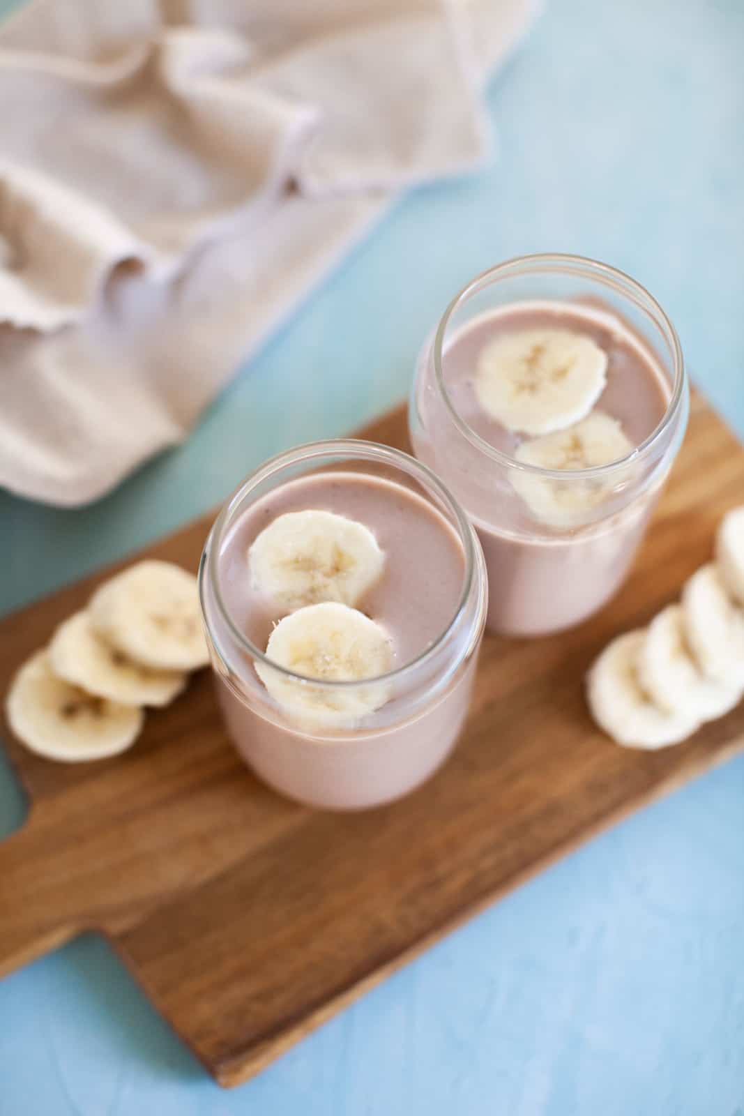 two banana smoothies on a wood board