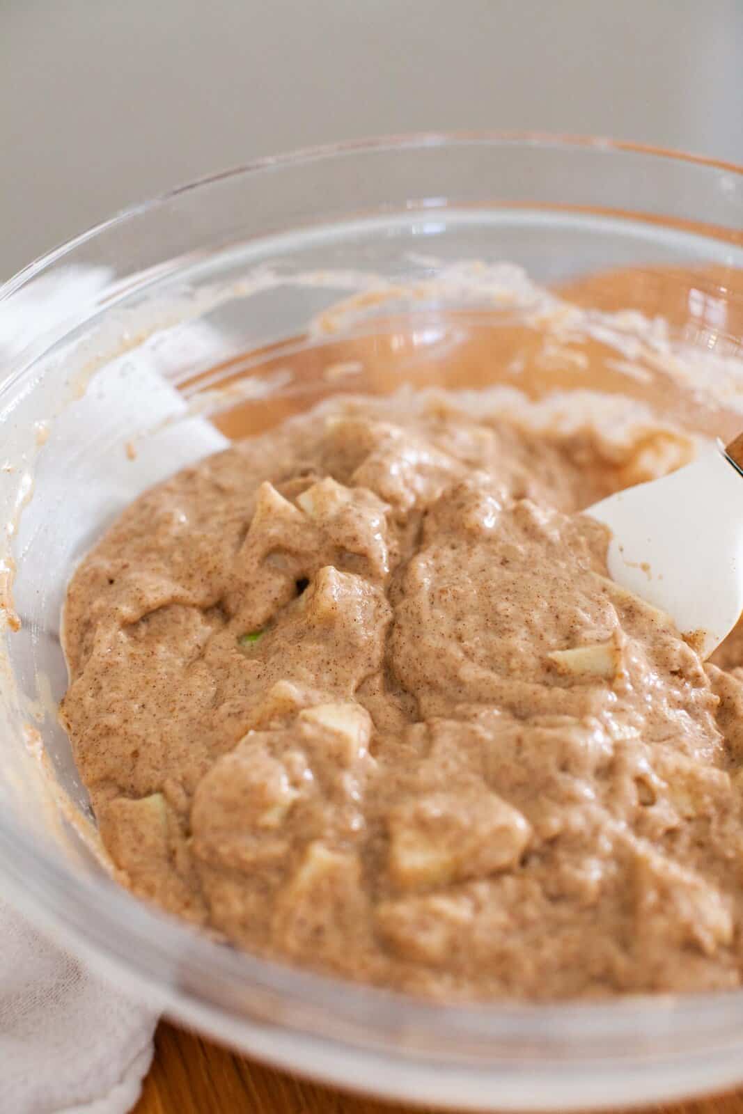 Rubber spatula in a mixing bowl of chunky batter.