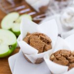 a tray of apple muffins in white wrappers