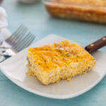 A slice of egg casserole on a spatula on a plate.