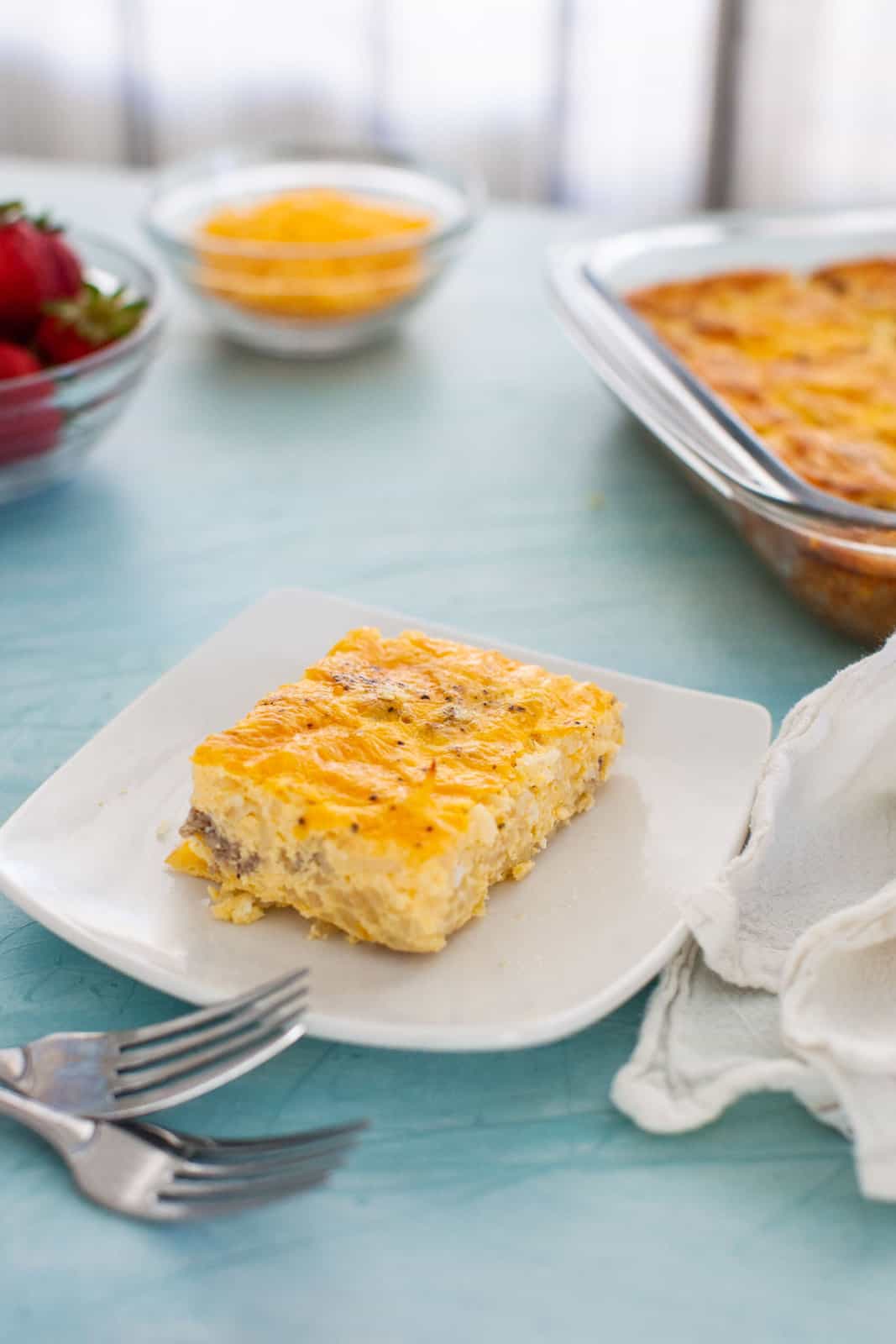 a breakfast scene featuring berries, orange juice and egg casserole.