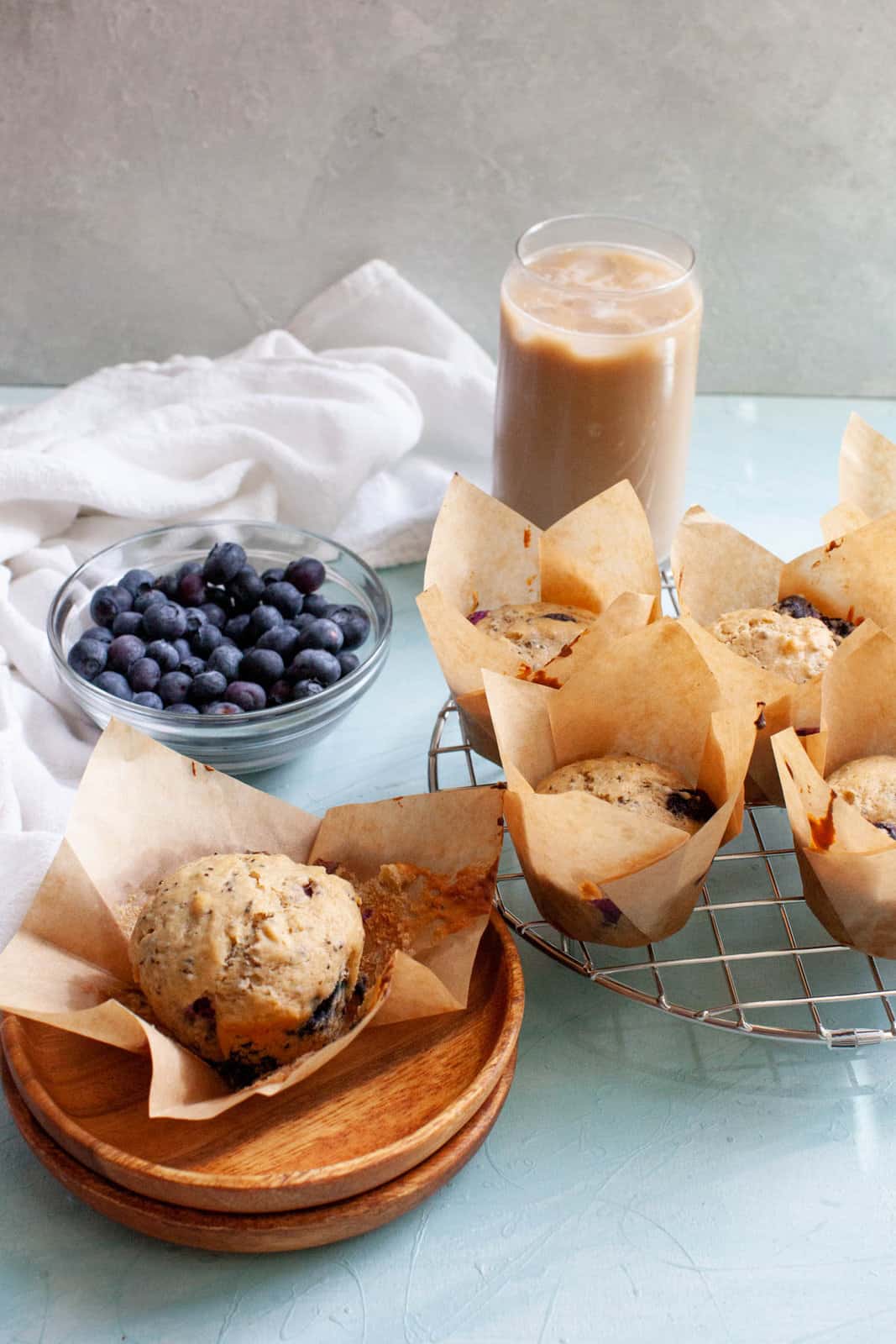 blueberry chia muffins on a plate and on a cooling rack