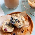 a blueberry chia muffin cut in half on a wood plate