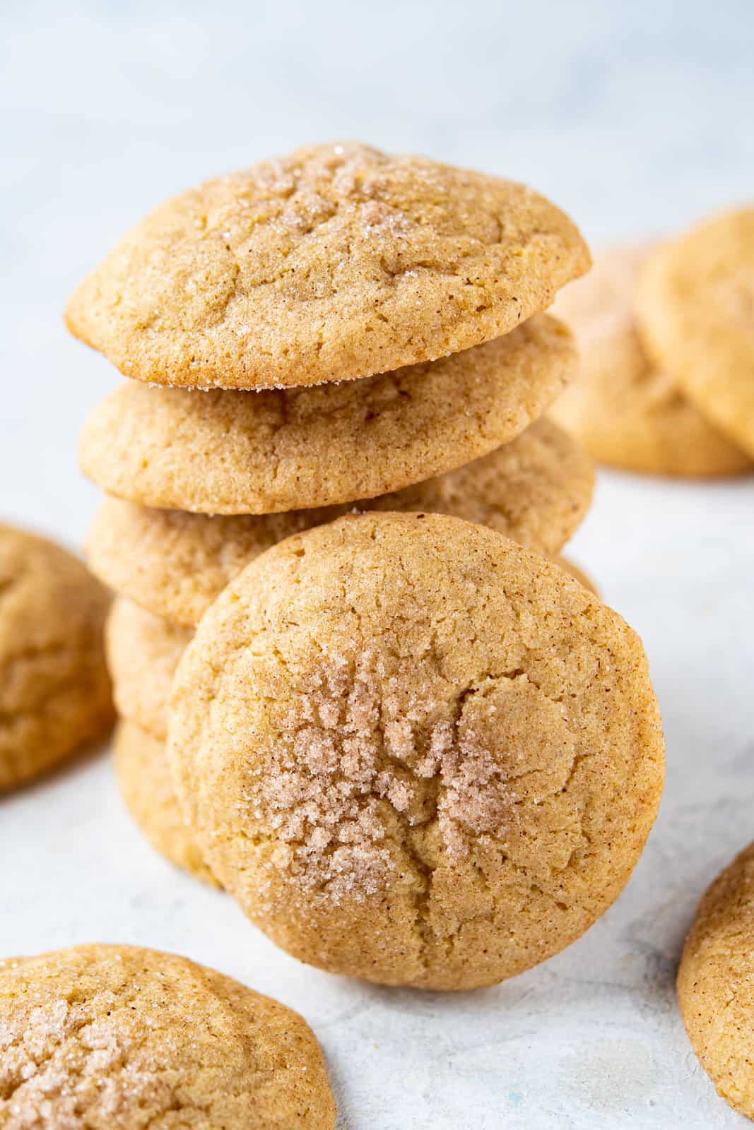 Chewy cinnamon cookies with cinnamon sugar on top arranged in a stack.