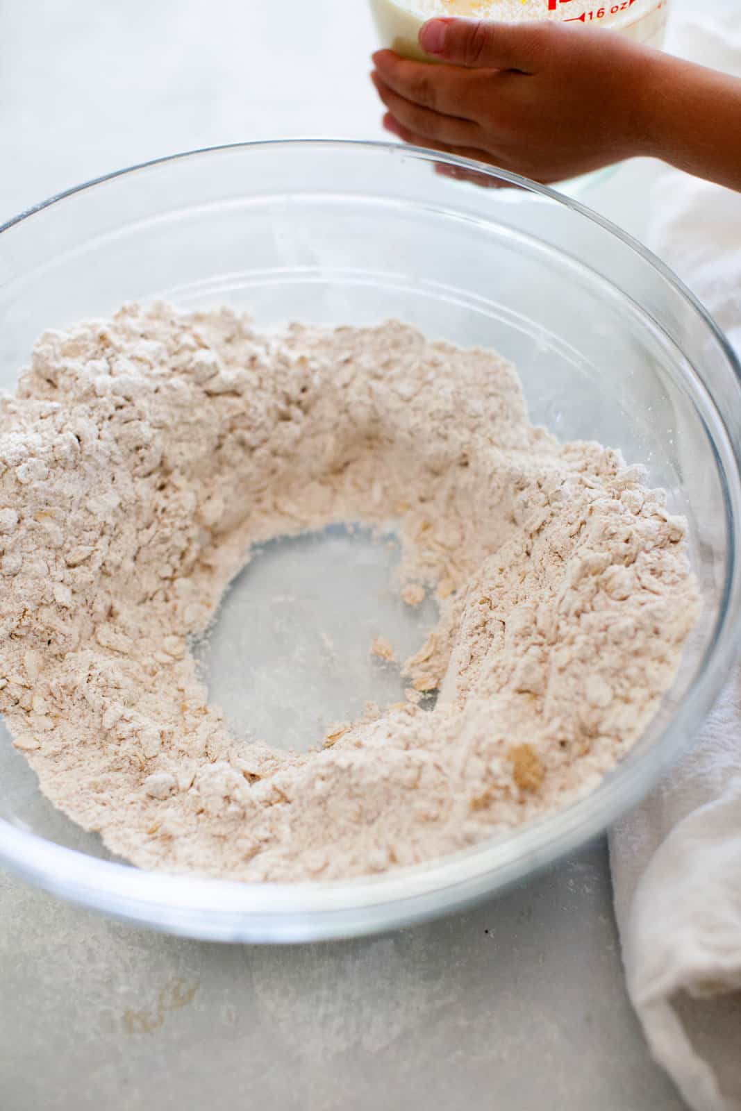A well in the center of a bowl of dry ingredients.
