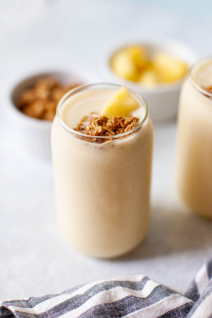 a sprinkle of granola on top of a pineapple smoothie.