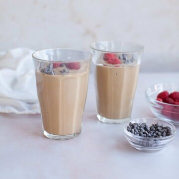 two chocolate smoothies on a pink background.
