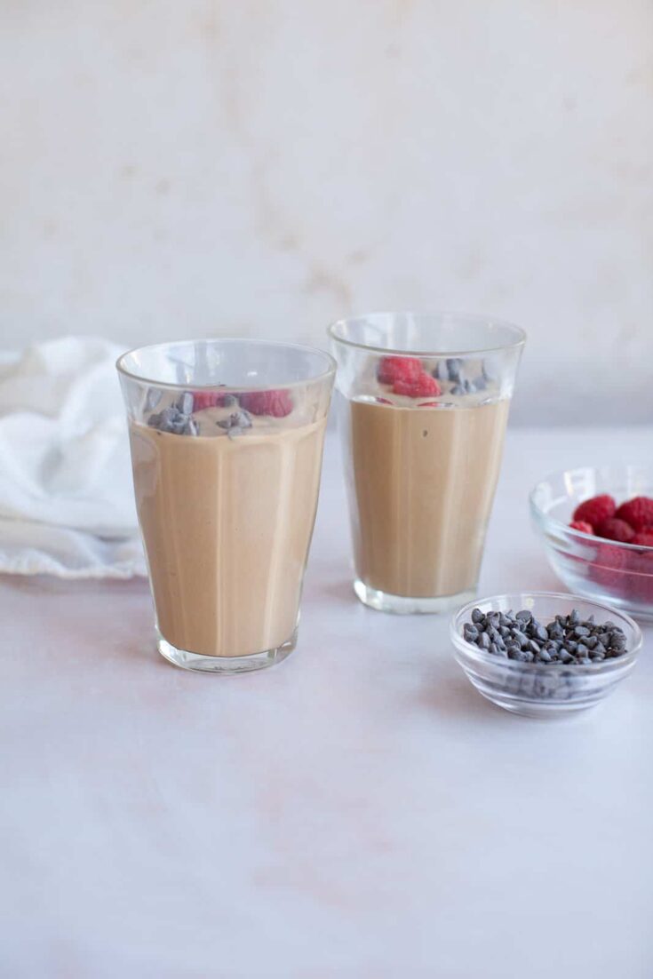 two chocolate smoothies on a pink background.